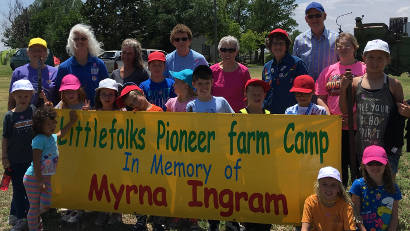 group with Littlefolks Pioneer Farm Camp sign